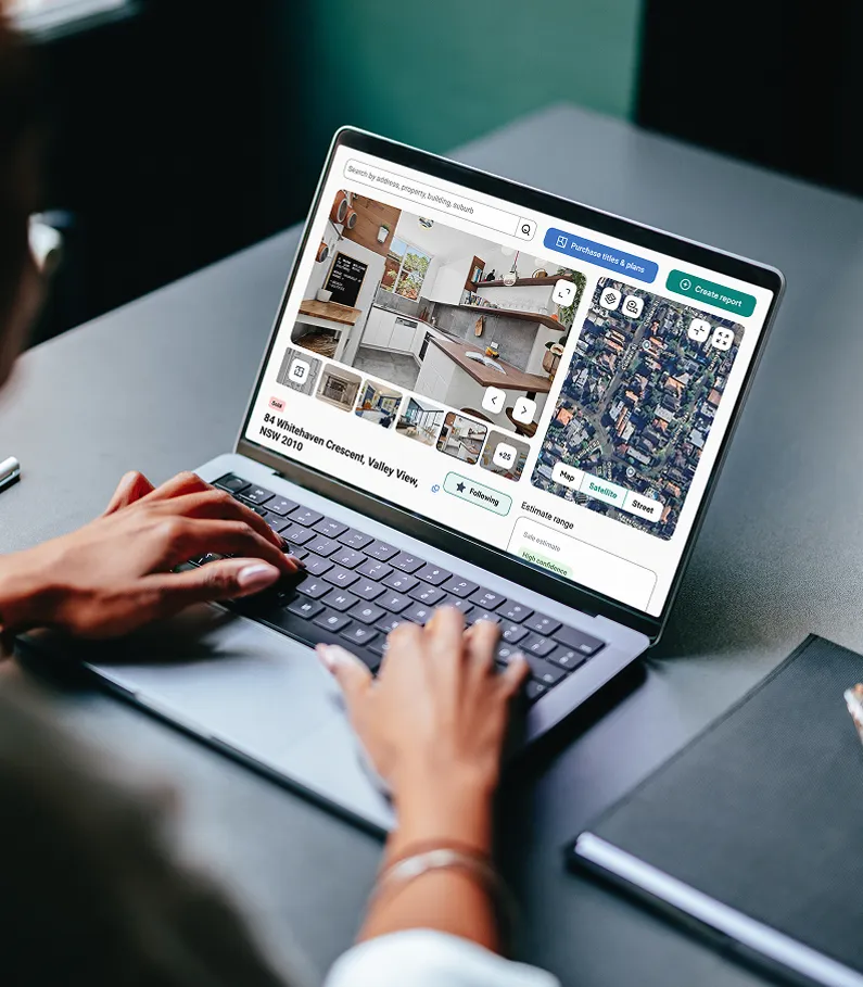 Person browsing property details and satellite view of a home listing on a laptop, showing interior photos and estimated value range.
