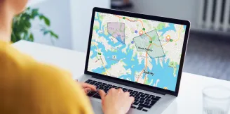 Person using a laptop to view custom mapped areas across Sydney suburbs on a property data platform.