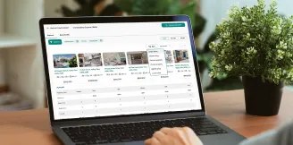 Person using a laptop to compare property listings and prices on a real estate platform, with a green plant on the desk nearby.