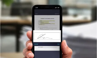 Person using a smartphone to digitally sign a document with an electronic signature.